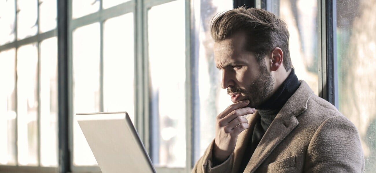 uomo perplesso legge il decreto davanti al pc